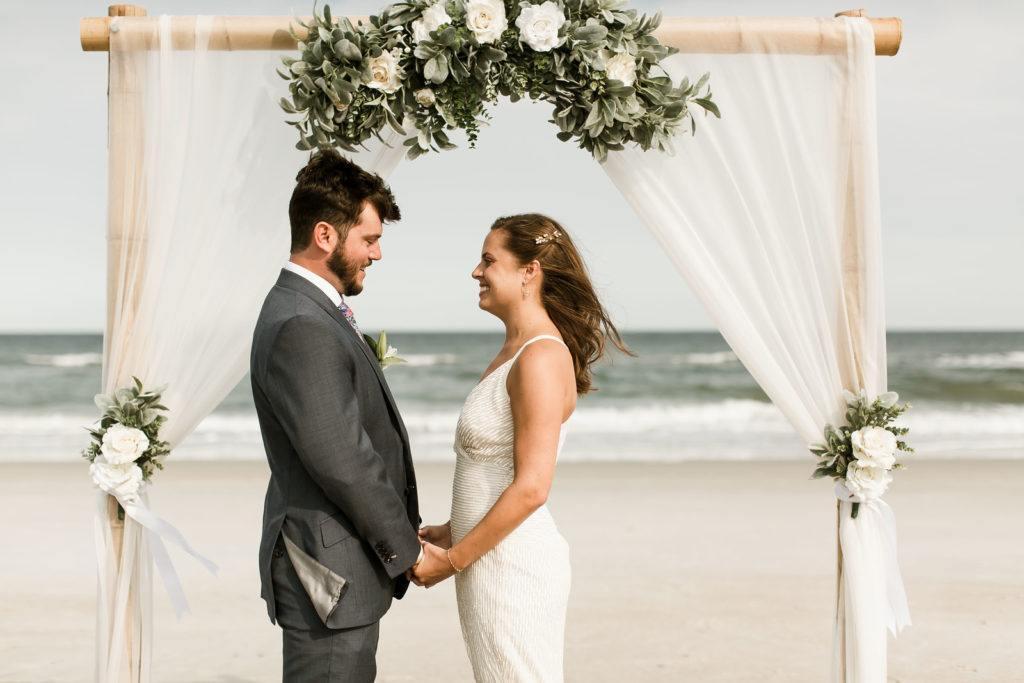 Bride and groom holding hands during their beach wedding ceremony